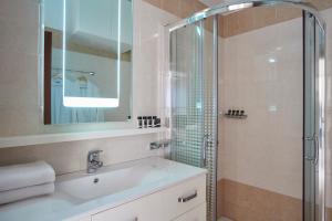 a bathroom with a sink and a shower at Skiathos Living by GHH in Skiathos +25 photos