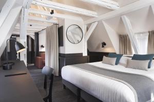 a bedroom with a bed and a desk and a mirror at Hôtel Du Dragon in Strasbourg +136 photos
