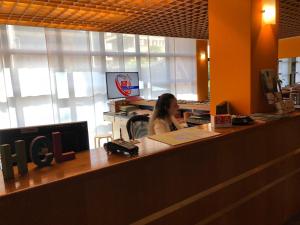 Una donna seduta a una scrivania in un ufficio di Hotel Ceresio a Lugano