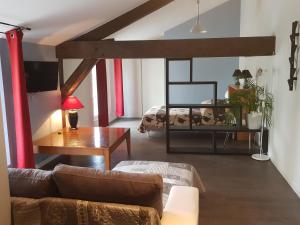 uma sala de estar com um sofá e uma mesa em Chambre d'Hôtes La Rose des Vents em Sathonay-Camp
