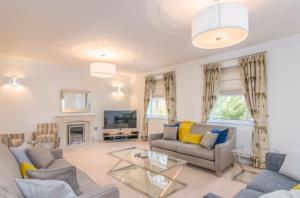 a living room with two couches and a tv at Jubilee Mansions 5* retreat in Peterborough