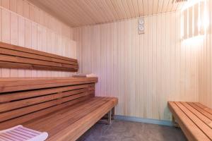 una sauna con 2 bancos de madera en una habitación en Résidence Pierre & Vacances Premium Presqu'Ile de la Touques, en Deauville