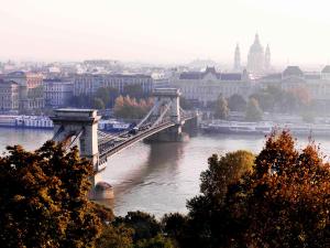 a bridge over a river with a city in the background at Four Seasons Hotel Gresham Palace Budapest in Budapest