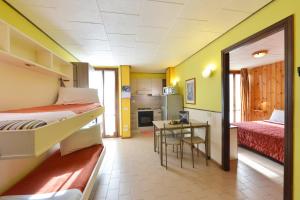 a room with two beds and a table and a kitchen at Residence Bellevue in Antey-Saint-André