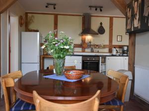 a kitchen with a wooden table with a vase of flowers on it at Spacious Apartment in Buschenhagen with Sauna in Buschenhagen