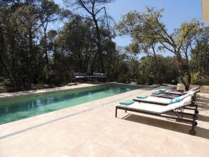 - une piscine avec 2 chaises longues à côté dans l'établissement La Villa Kallisté, à Vacquières