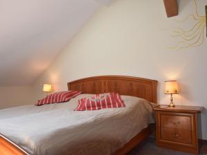 a bedroom with a bed with two red pillows on it at Ferienwohnung Im Heumond in Buschhagen in Buschenhagen