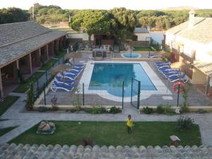 a child standing in front of a swimming pool at Residencial La Teja in Zahora