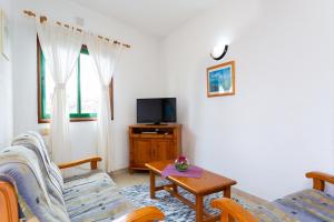 sala de estar con 2 sillas y TV en Finca La Gaviota - El Marmol, en Icod de los Vinos