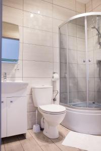 uma casa de banho com um WC, um chuveiro e um lavatório. em Sevilla Park em Międzywodzie