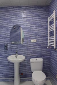 a blue tiled bathroom with a toilet and a sink at Guesthouse Kiko in Sighnaghi