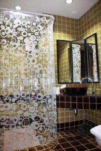 a bathroom with a shower curtain and a sink at Wangburapa Grand Hotel in Chiang Mai