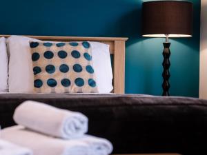 a hotel room with a bed with a lamp and towels at Lakeview Holiday Cottages in Bridgwater
