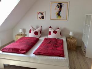 シュプレムベルクにあるVilla am Schwanenteichのベッドルーム1室(赤いシーツを使用したベッド2台付)