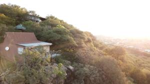 een huis aan de zijkant van een berg bij Lentswe Lodge in Serowe