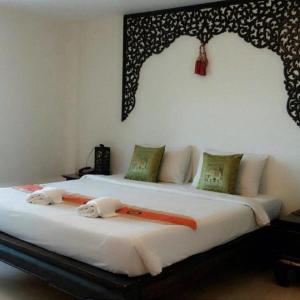 a bedroom with two beds with towels on them at Wangburapa Grand Hotel in Chiang Mai
