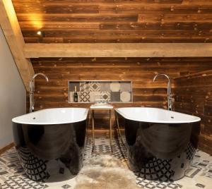 uma casa de banho com 2 banheiras num piso de azulejo em Macdui Lodge em Aviemore