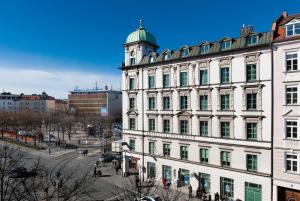 een groot wit gebouw met een klokkentoren bij MOMA1890 Boutique Hotel in München