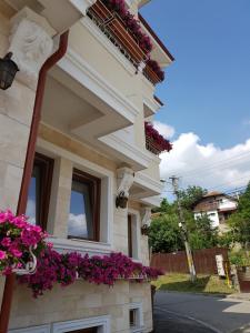a building with a balcony and a window at Pensiunea Geostar in Curtea de Argeş
