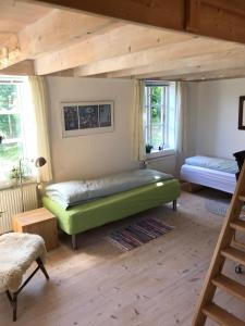 1 dormitorio con 1 cama verde en una habitación en Tranum Lys og Glas, en Brovst