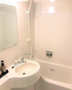 y baño blanco con lavabo y bañera. en Gran Hotel en Shingu
