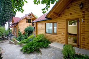 una pequeña casa de madera con una pasarela de piedra delante de ella en 4-sezona Hotel, en Alupka