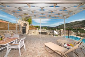 a patio with a table and chairs and a pool at Villa Provenza in Anafonítria