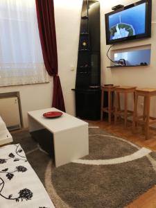 een woonkamer met een witte tafel en een tv bij Lola 1 in Belgrado