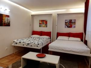 een kamer met twee bedden en een tafel erin bij Lola 1 in Belgrado