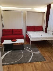 een kamer met een bed en een rode bank bij Lola 1 in Belgrado