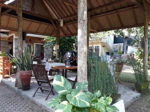un patio al aire libre con mesa, sillas y plantas en Manuh Guest House, en Nusa Dua