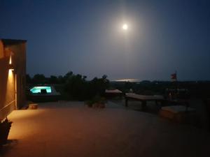 a moon rising over a patio at night at Terre Di Vendicari in Noto