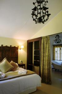 - une chambre avec un lit et un lustre dans l'établissement Almar View Guest House, à Nelspruit