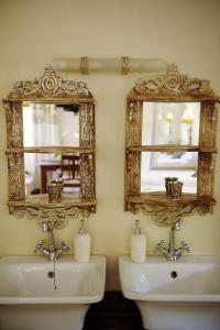 baño con 2 espejos y lavamanos en Almar View Guest House, en Nelspruit