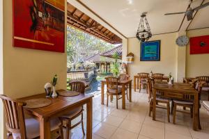 a dining room with wooden tables and chairs at Sagitarius Inn in Ubud