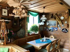 ein Esszimmer mit einem Tisch, Stühlen und einem Kronleuchter in der Unterkunft Pension Bennelliebschänke in Seiffen