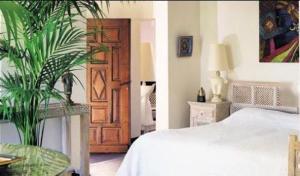a bedroom with a bed and a wooden door at Mangio Fango Hotel et Spa in Saintes-Maries-de-la-Mer