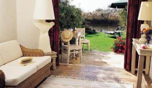 a living room with a couch and a table and chairs at Mangio Fango Hotel et Spa in Saintes-Maries-de-la-Mer