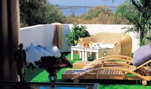 a patio with two wicker chairs and a table at Mangio Fango Hotel et Spa in Saintes-Maries-de-la-Mer