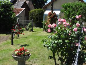 a garden with roses and a vase of flowers at Chez Mamie in Beynat