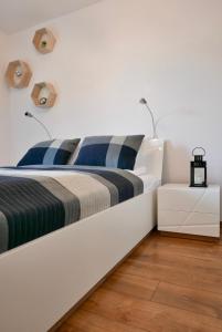 biała sypialnia z dużym łóżkiem z 2 poduszkami w obiekcie CHILLIapartamenty - Bliżej Morza - GEO w Kołobrzegu