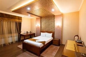 a hotel room with a bed and a desk at Salut Hotel Almaty in Almaty