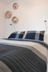 łóżko z niebiesko-białą pościelą i poduszkami w obiekcie CHILLIapartamenty - Bliżej Morza - GEO w Kołobrzegu