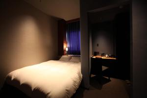 A bed or beds in a room at Kojohama Onsen Hotel