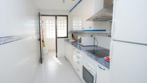 uma cozinha branca com um lavatório e um frigorífico em Marina de la Duquesa 225 em Manilva