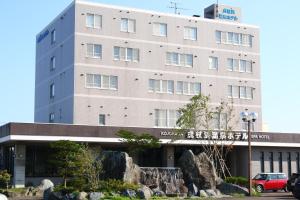 un edificio con un coche aparcado delante de él en Kojohama Onsen Hotel, en Shiraoi