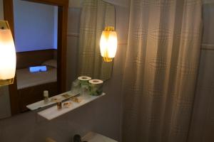 y baño con lavabo, espejo y aseo. en Hotel Loreto en Loreto