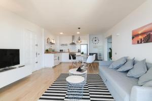 サンタクルス・デ・テネリフェにあるTabaiba Ocean View Apartmentの白いリビングルーム(ソファ付)、キッチンが備わります。