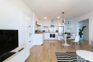 a kitchen and living room with a large television and a table at Tabaiba Ocean View Apartment in Santa Cruz de Tenerife