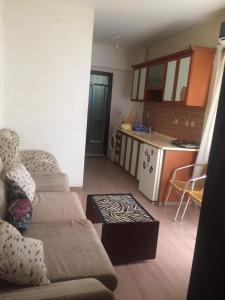 a living room with a couch and a kitchen at Times Apart in Çeşme